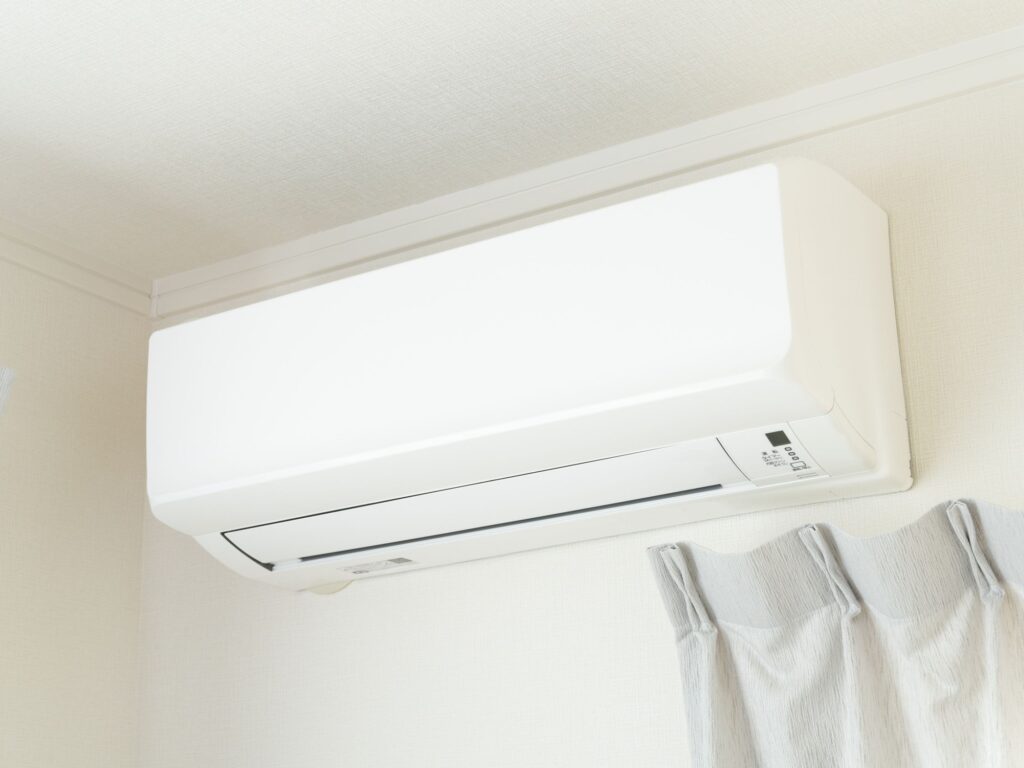 Clean wall-mounted air conditioner installed near the ceiling.
