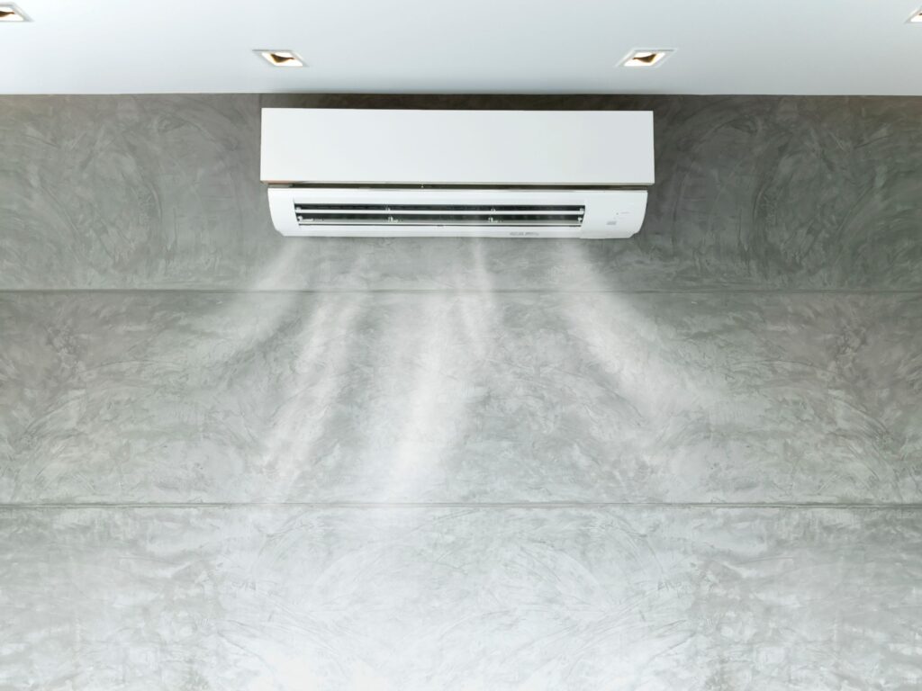 Wall-mounted AC blowing cool air into a modern room.